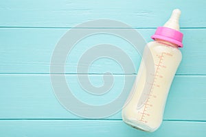 Baby milk bottle on blue wooden background