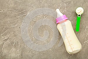Baby milk bottle with powder on grey background