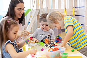 Baby minder playing with kids in day care center