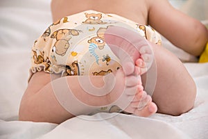 baby in modern eco stacks of cloth diapers