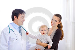 Baby on mom hand touching stethoscope of doctor