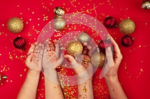 Baby and mom hands holding Christmas decorations.