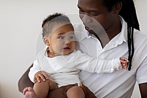 Baby Mood Swings. Black Father Holding Cute Crying Infant Child In Arms
