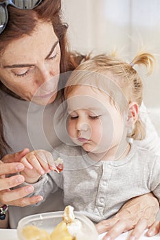 Baby with mother eating from tupperware