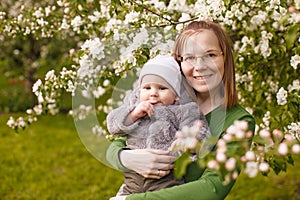 Baby with mother in the park in the rays of sunset. Toddler with mom on the nature outdoors. Backlight. Summertime family scene