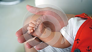 Baby in mothers hands. The child`s hand is in the hands of the Father.