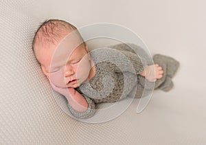 Baby napping in a grey outfit, closeup