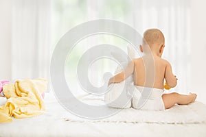 Baby in nappy holding soft rabbit