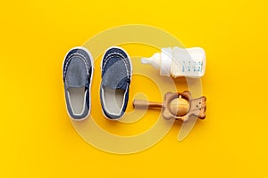 Baby newborn blue booties with bootle of milk and wooden toy