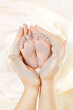 Baby Newborn Feet in Mother Hands. Beautiful New Born Kid Foot, Family Love Concept