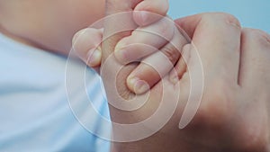 Baby newborn holding a mom hand. kid dream concept. close-up baby hand grabs the finger of the mother hand. newborn baby