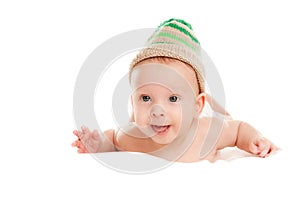 Baby newborn lying on her stomach on the bed in a funny knitted hat isolated on white background, the concept of choosing baby clo