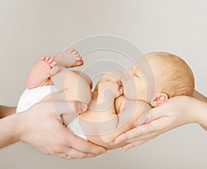 Baby newborn sleeping on parents family hands