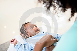 Baby newborn son, smile and looking at mother while his mother being held