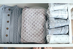 Baby or newborn things of white, blue, grey colors in drawer. Lady fly system, kondo konmary concept