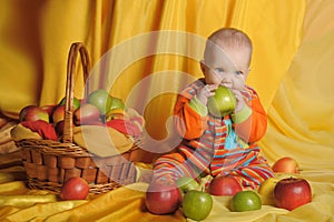 Baby next to a basket of apples