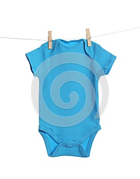 Baby onesie hanging on clothes line against white background