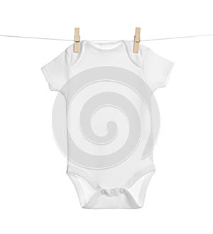 Baby onesie hanging on clothes line against white background