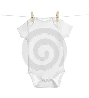 Baby onesie hanging on clothes line against white background photo