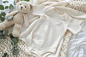 Baby onesie mockup white cotton bodysuit with teddy bear and eucalyptus on ivory blanket