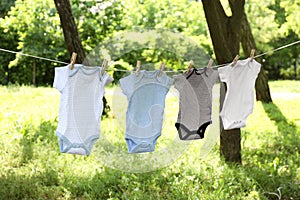 Baby onesies hanging on clothes line