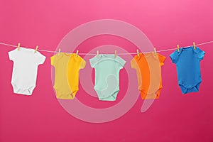 Baby onesies hanging on clothes line