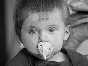 Baby with pacifier, black and white