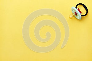 Baby pacifier on a yellow background