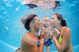 Baby with parents learn to swim underwater in swimming pool