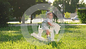 baby in the park. baby toddler swinging on a rocking horse toy in the park happy summer. happy family a kid dream