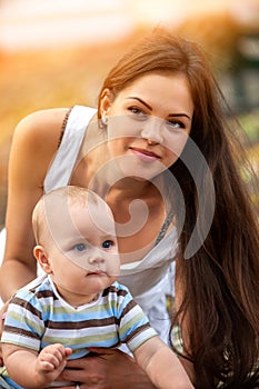 Baby in park outdoor. Kid on mom`s hands.