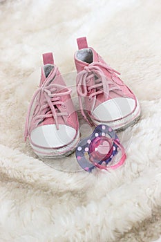 Baby pink shoes and dummy