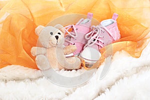 Baby pink shoes and teddy bear