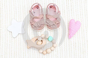 Baby pink shoes and wooden teether
