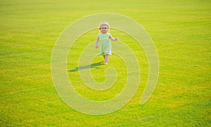 Baby play in green grass. Child development. Adorable little kid walking in an autumn field.