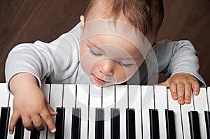 Baby play music on piano keyboard