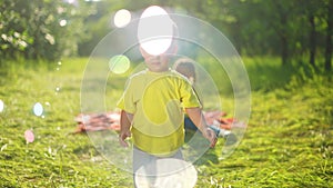 baby play with soap bubbles. happy family a kids playing picnic in the park with soap bubbles. happy family kid concept