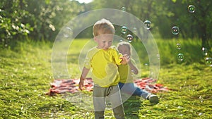 baby play with soap bubbles. happy family a kids playing picnic in the park with soap bubbles. happy family kid concept
