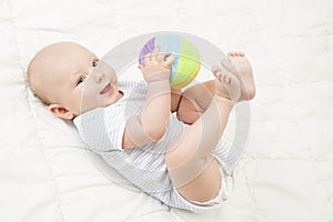 Baby Play Toy Ball, Happy Kid Lying on Back Playing Soft Toys photo