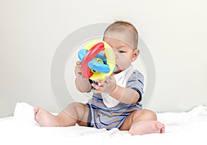 Baby playing with ball in bed