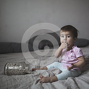 Baby playing on bed of beans, early development, natural toys,