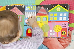 Baby playing with colorful book