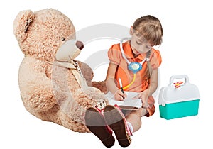 Baby is playing doctor, treats a bear