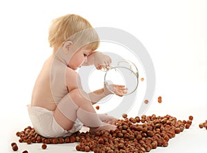 Baby playing with hazelnuts