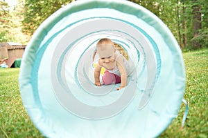 Baby playing inside a toy tunnel