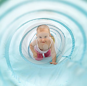 Baby playing inside a toy tunnel