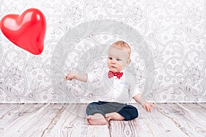 Baby playing with red balloon