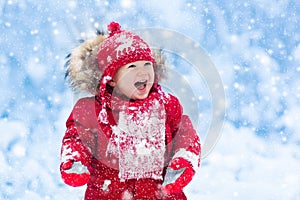 Baby playing with snow in winter.