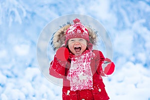 Baby playing with snow in winter.