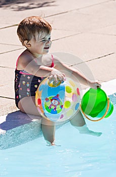 Baby playing in swimming pool water